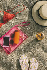 High angle view of beach supplies with smart phone on sand - CAVF70282