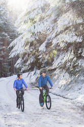 Couple mountain biking in snow - HOXF04420