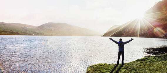 Excited man at sunny lake - HOXF04425