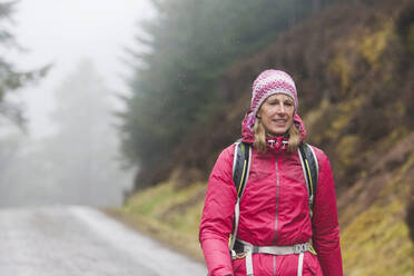 Woman hiking in rain - HOXF04427