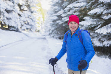 Glücklicher älterer Mann beim Wandern im Schnee - HOXF04448
