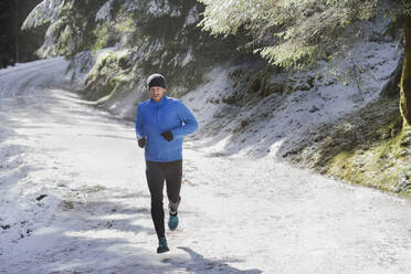 Mann joggt im Schnee - HOXF04450