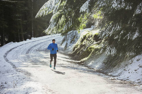 Mann joggt im Schnee - HOXF04453