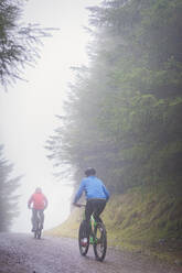 Couple mountain biking in rain - HOXF04467