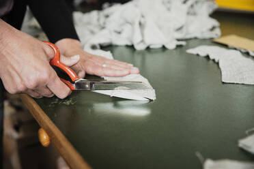 Close up of woman's hand cutting a fabric with scissor - SDAHF00024