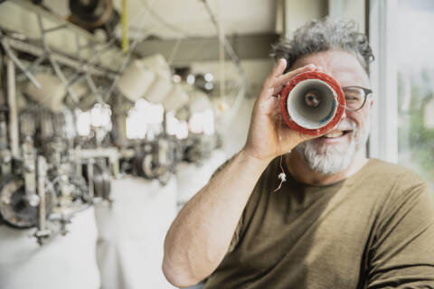 Producer of a fashion label during control in circular knitting mill, looking through roll stock photo