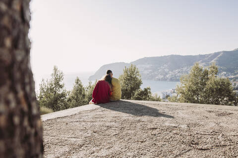 Young couple sitting on viewpoint stock photo