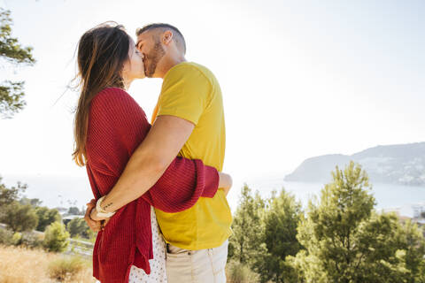 Young couple kissing each other at a viewpoint stock photo