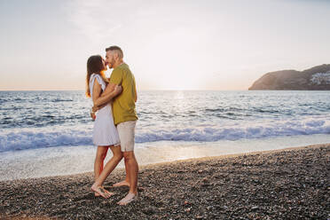 Young couple kissing at the beach during sunset - LJF01092