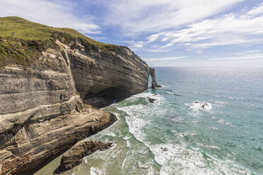 New Zealand, Cliffs and natural arch of Cape Farewell headland on sunny day - FOF11386