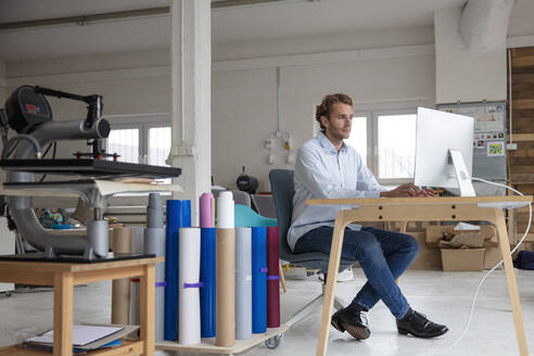 Young businessman working on desk, using computer - MOEF02696