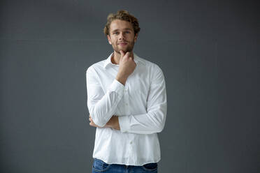 Porträt eines jungen Geschäftsmannes, der ein weißes Hemd trägt - MOEF02714