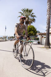 Lächelnder reifer Mann mit Fahrrad - TCF06216