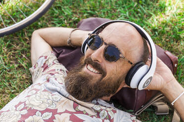 Mature man with red basecap, sunglasses and white headphones - TCF06228