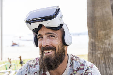 Lächelnder reifer Mann mit Virtual-Reality-Brille - TCF06232