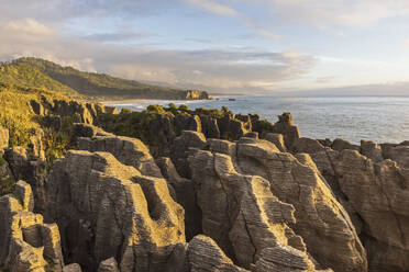 New Zealand, Buller District, Punakaiki, Limestone Pancake Rocks formation and coastal blow hole at dusk - FOF11395