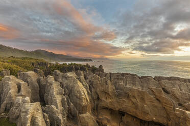 New Zealand, Buller District, Punakaiki, Limestone Pancake Rocks formation and coastal blow hole at dusk - FOF11399