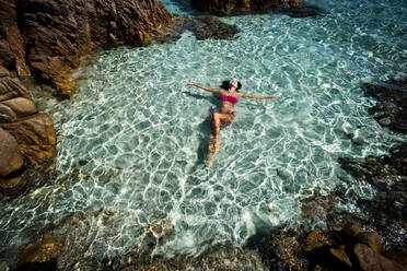 Frau im Bikini genießt das klare Meerwasser in einer Lagune, Insel La Maddalena, Sardinien, Italien - CUF53539