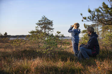 Father and son exploring forest, Finland - CUF53550