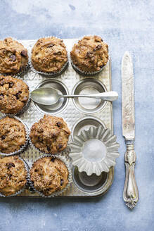 Frisch gebackene Muffins mit Schokoladenstückchen auf dem Backblech - CUF53616