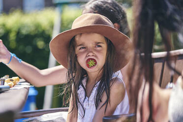Mädchen träumt mit Erdbeere im Mund - CUF53662