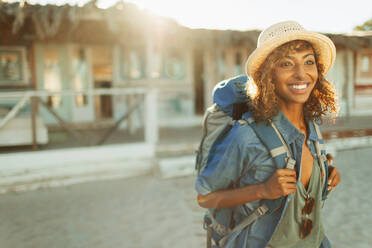 Porträt glückliche junge weibliche Backpacker außerhalb sonnigen Strand Hütte - HOXF04613