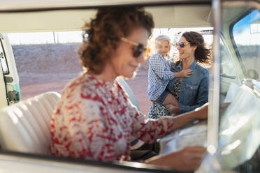 Multi-generation women with map in van - HOXF04623