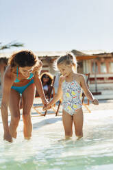 Mutter und Tochter spielen im sonnigen Meer - HOXF04639