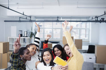 Happy businesswomen celebrating new office, taking selfie - HOXF04665