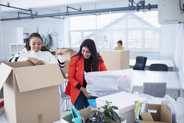 Geschäftsfrauen packen aus, ziehen in ein neues Büro - HOXF04667