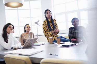 Attentive businesswomen listening in conference room meeting - HOXF04685