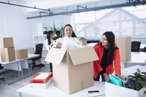 Geschäftsfrauen packen aus, ziehen in ein neues Büro - HOXF04703