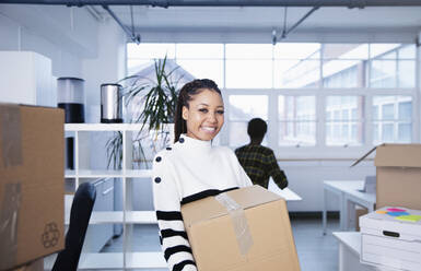 Porträt einer selbstbewussten, glücklichen Geschäftsfrau beim Einzug in ein neues Büro - HOXF04711