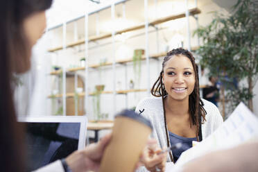 Businesswomen talking in meeting - HOXF04803