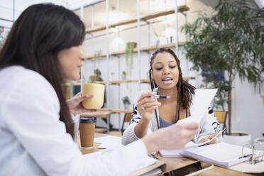 Geschäftsfrauen besprechen Papierkram im Büro - HOXF04837