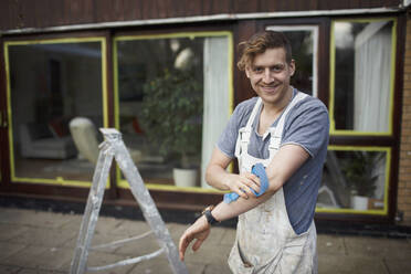 Portrait confident male painter outside house - HOXF04900