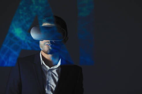 Doppelbelichtung Geschäftsmann mit Virtual-Reality-Simulator-Brille gegen AI-Text - CAIF23388
