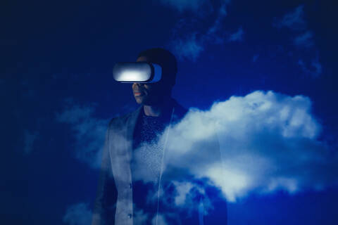 Double exposure businessman with virtual reality simulator glasses against blue sky with clouds stock photo