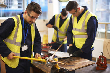 Männliche Schüler benutzen Geräte in der Werkstatt des Werkunterrichts - CAIF23438