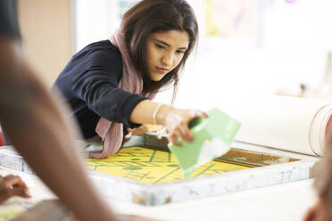 Künstlerin beim Siebdruck im Atelier - CAIF23479