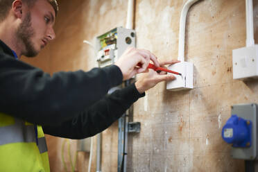 Männlicher Student der Elektrotechnik beim Üben in der Werkstatt - CAIF23482