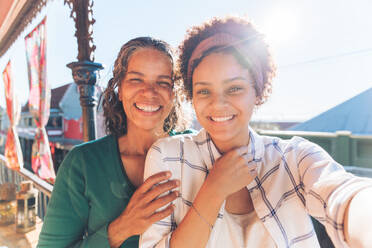 Selfie Porträt Standpunkt lächelnd, glücklich Mutter und Tochter auf sonnigen Balkon - CAIF23493