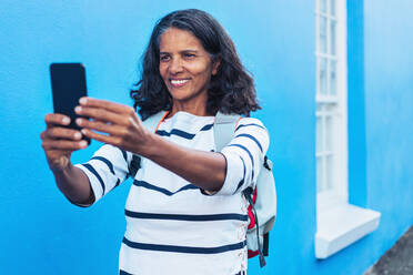 Glückliche Touristin macht Selfie mit Smartphone - CAIF23504