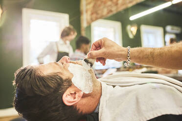 Mann lässt sich im Friseursalon rasieren - CAIF23530