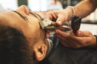 Nahaufnahme eines Mannes, der in einem Friseursalon rasiert wird - CAIF23542