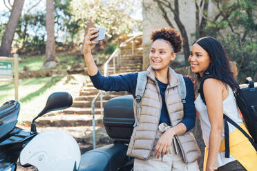 Glückliche junge Frauen Freunde nehmen Selfie mit Kamera-Handy auf Motorroller - CAIF23599