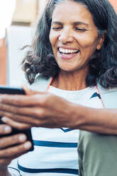 Lächelnde, glückliche Frau mit Smartphone - CAIF23612
