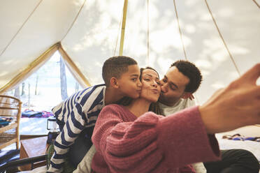 Glückliche, liebevolle Familie beim Selfie in der Camping-Jurte - CAIF23663