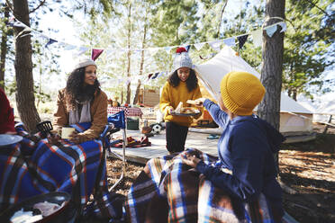 Familie beim Essen auf einem Campingplatz im Wald - CAIF23678