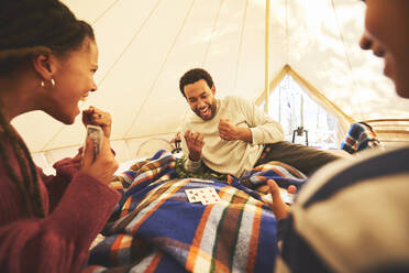 Familie spielt Karten in der Camping-Jurte - CAIF23682